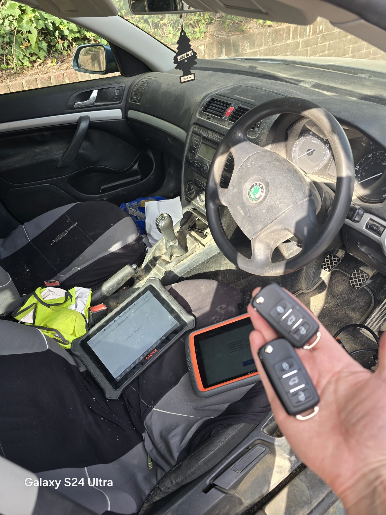 Two newly programmed VW-group flip keys held next to a Skoda Octavia after an all-keys-lost job