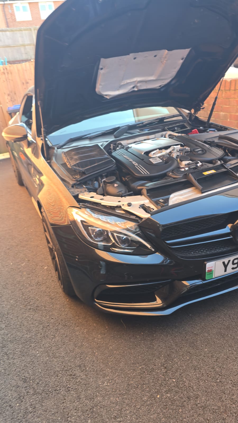 Mercedes-AMG C63 with the bonnet open showing the twin-turbo V8 during a tuning session