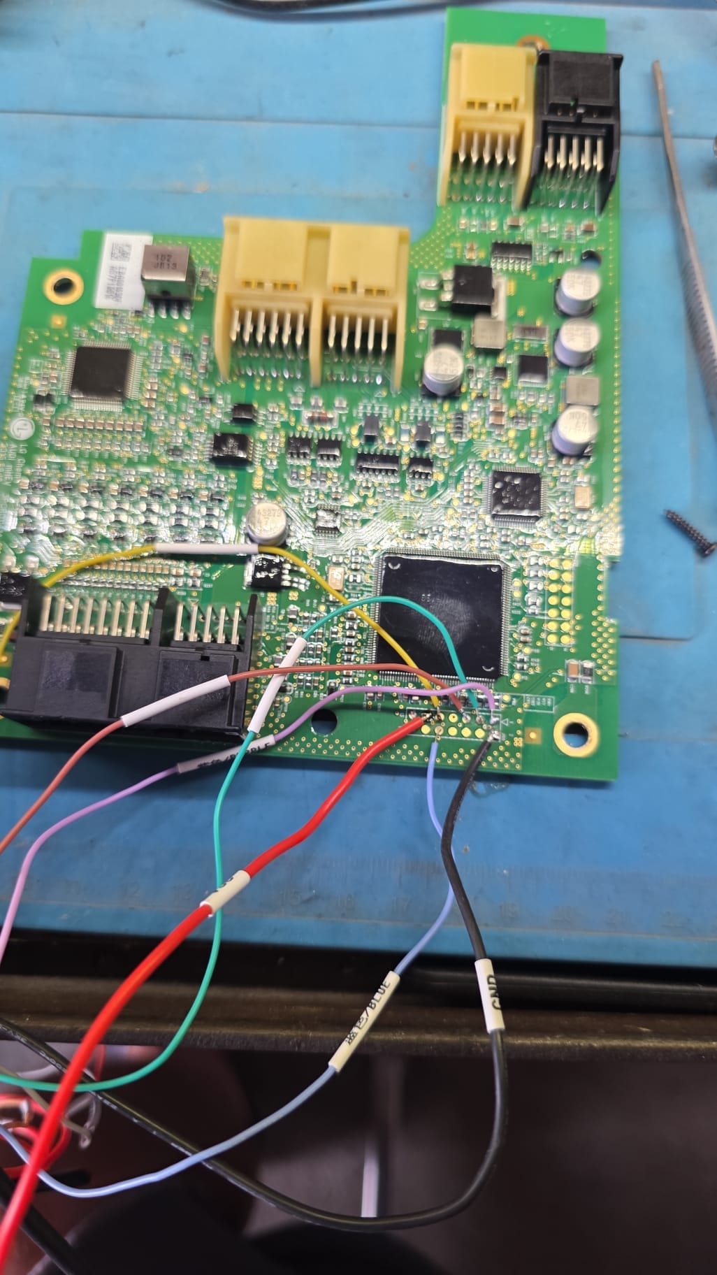 ECU circuit board opened on the bench with pinout wiring connected for reading and programming