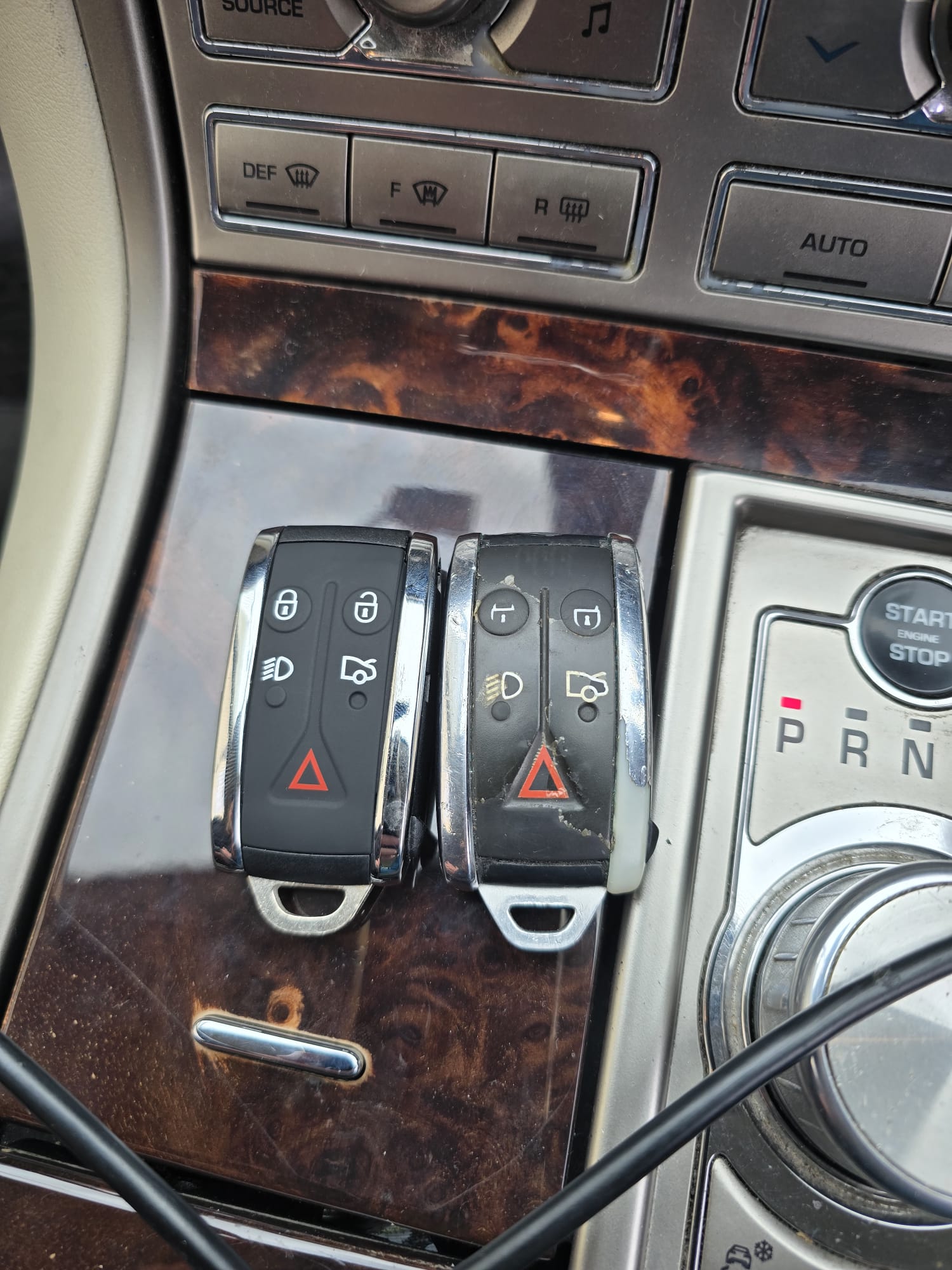 New Jaguar XF smart key next to the worn original on the centre console