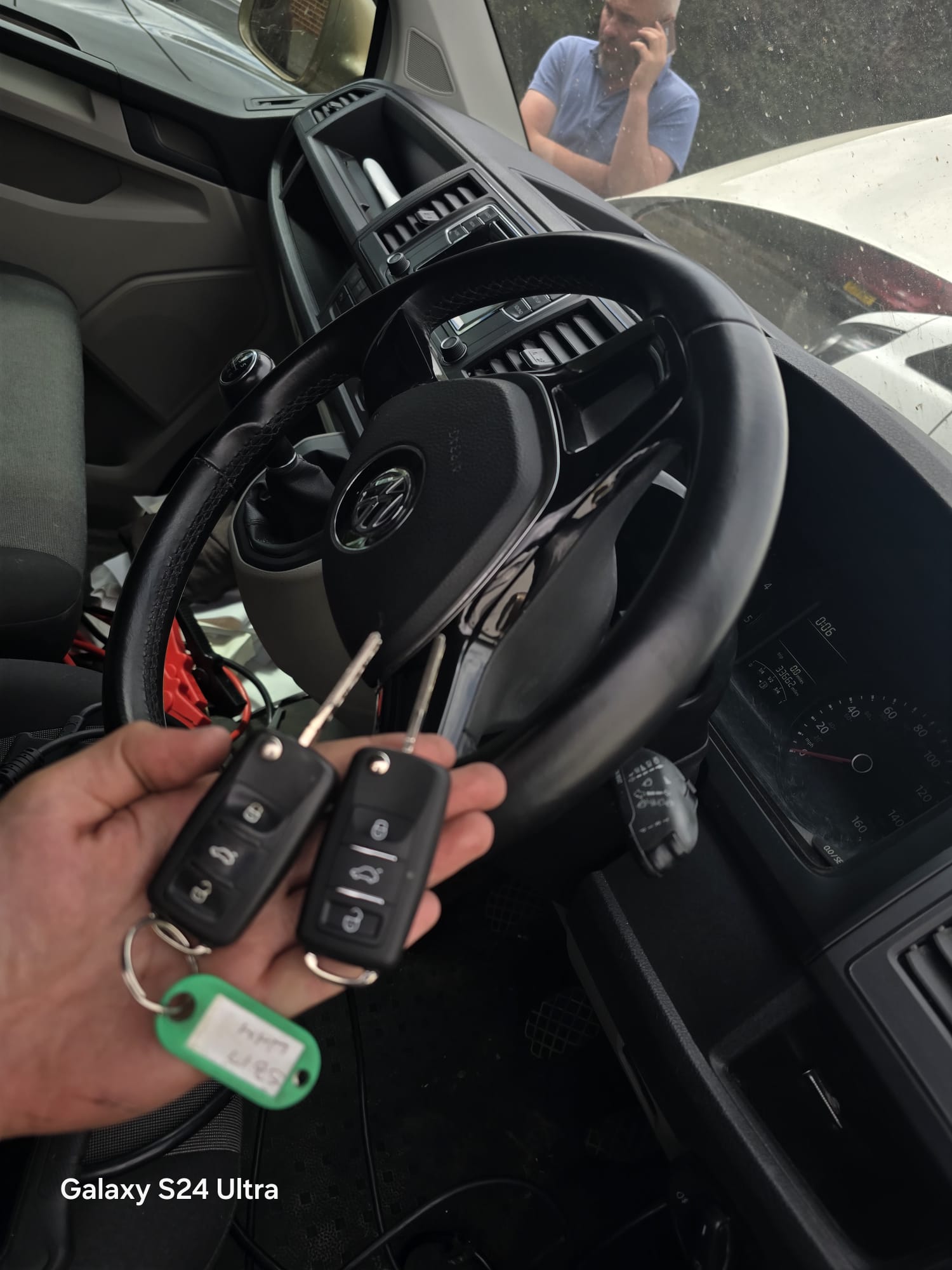 Two replacement VW Caddy flip keys held in front of the steering wheel after an all-keys-lost job