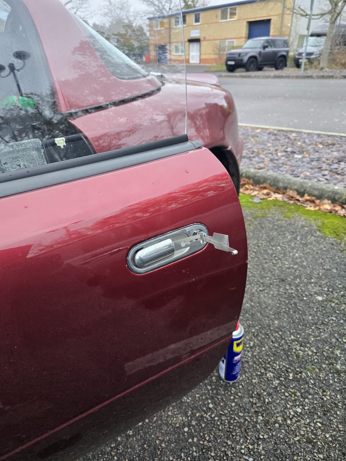 Damage-free car unlock on a red saloon door using non-destructive entry tools